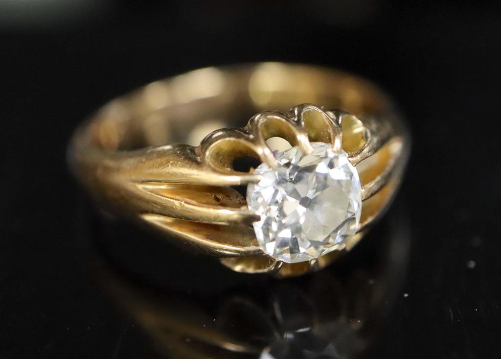 An early 20th century gold and old cushion cut claw set solitaire diamond ring, with fluted shoulders,